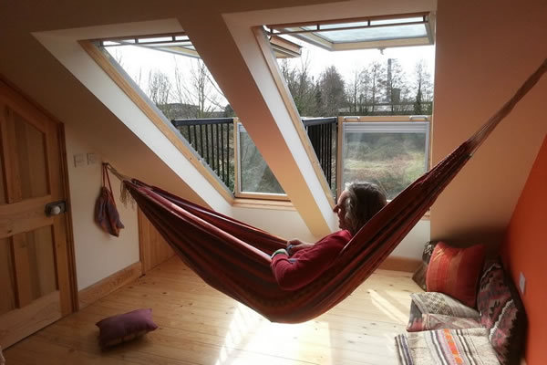 Man in hammock by windows